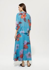 Leichtes, fließendes Kleid und Oberteil-Set mit einem türkisfarbenen Hintergrund und großen, mehrfarbigen Blumenmustern. Rundhalsausschnitt, Dreiviertelärmel.