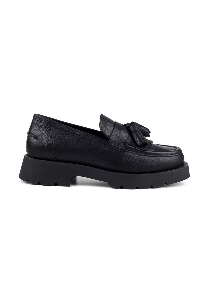 Black leather loafer with a rounded toe, decorative tassels, and a chunky, textured rubber sole. Features a smooth upper construction.