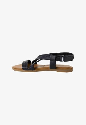 Flat sandals made of black leather with crisscross straps and an ankle strap. Features a tan rubber sole and smooth texture.