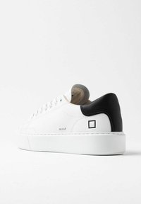 Hvide lædersneakers med en sort struktureret hæl. Har en hvid gummisål og subtil branding på siden. Runde snørebånd og en glat overflade.