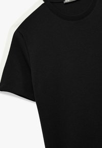 Zwarte T-shirt met korte mouwen, voorzien van een textuurstof en een witte accent op de schouder. Klassieke ronde hals.