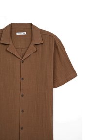 Camicia marrone a maniche corte con colletto, realizzata in tessuto leggero, chiusura a bottoni e una sottile trama. Taglia indicata come XL.
