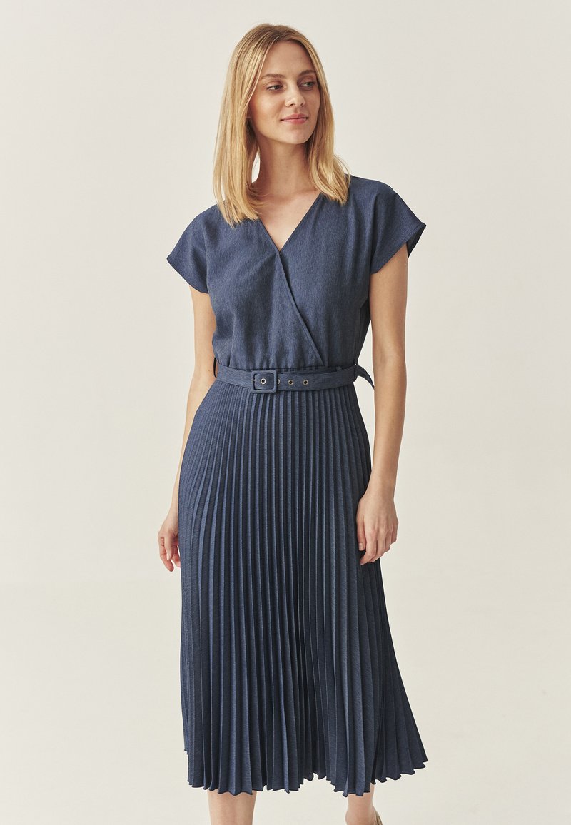 Wickelkleid aus dunklem Denim mit kurzen Ärmeln, plissiertem Rock und tailliertem Detail. Glatte Textur und knielanges Design.