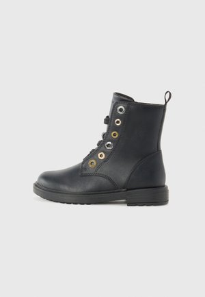 Schwarze Leder-Stiefelette mit runder Zehenform, Schnürverschluss, goldenen, silbernen und schwarzen Ösen sowie einem niedrigen Blockabsatz. Strukturierte Oberflächen.