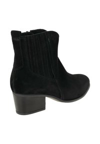 Zwarte leren enkellaars met een ronde neus, geribbelde panelen en een lage blokhak. Voorzien van een rits aan de zijkant voor gemakkelijk aantrekken.