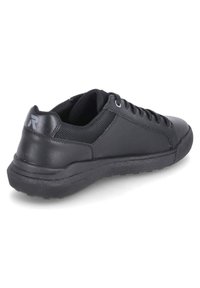 Svart sportskor med övre i slät läder, meshinlägg, rund tå och mönstrad gummisul. Snören och liten logodetalj på hälen.