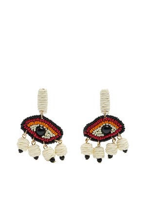 Kolczyki wykonane z koralików w kształcie stylizowanych oczu z czarnymi, czerwonymi, pomarańczowymi i białymi koralikami oraz kremowymi frędzlami z koralików zwisającymi na dole.
