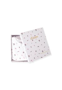 Witte t-shirt met een bloemen- en hartpatroon, gepresenteerd in een kleurrijke cadeauverpakking met de merknaam "Etam" in gouden letters.