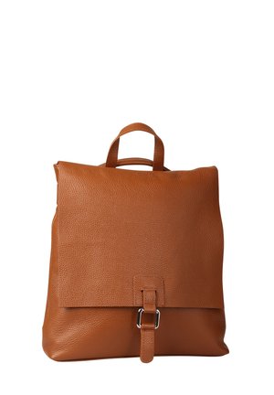 Bruine leren rugzak met een bovenhandvat, voorklep bevestigd met een riem en zilveren gesp, weergegeven tegen een witte achtergrond.