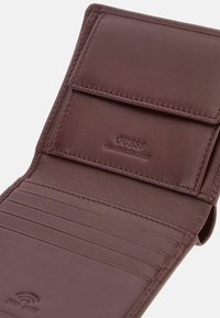 Portafoglio in pelle marrone con finitura testurizzata, dotato di più slot per carte e chiusura a scatto. "GUESS" impresso all'interno.