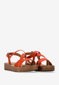 Sandalias naranjas con tiras, con un acabado texturizado y una suela de cuña de madera, que presentan correas entrelazadas y una hebilla de metal para un ajuste ajustable.