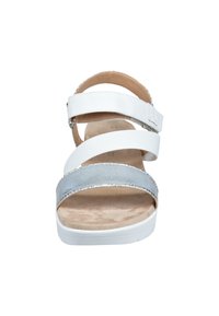 Sandale blanche et argentée avec trois sangles réglables, une surface lisse, une semelle intérieure rembourrée et un talon plat pour le confort.