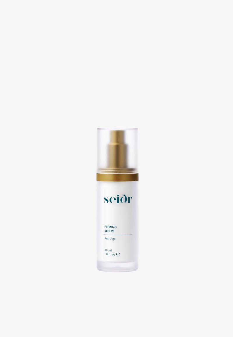 Klar glassflaske med en gullpumpe-topp, merket "FIRMING SERUM" i teal, som inneholder 30 ml anti-aging serum. Jevn, moderne design.