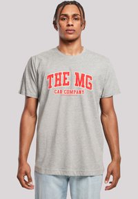 Gray cotton t-shirt featuring large red text reading "THE MG CAR COMPANY" across the chest. Short sleeves and a relaxed fit.