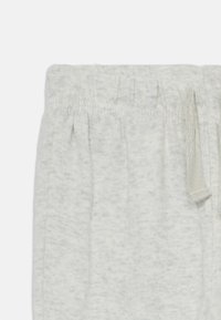 Hellgraue Baumwoll-Sweatpants mit Elastischem Bund, Schnürdetail und subtiler melierter Textur, die weiche Stofffalten zeigt.