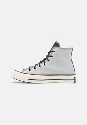 High-top gray canvas sneaker with black laces, white rubber sole, and black stripe detail, shown in side profile on a white background.