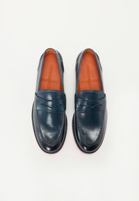 Ναυτικό μπλε δερμάτινα λουστρίνια με απαλή υφή, στρογγυλή μύτη και ραφές. Διαθέτουν διακοσμητική μπροστινή ταινία και καφέ εσωτερικά πέλματα.