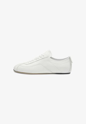 Witte lage leren sneaker met vetersluiting aan de voorkant, subtiele stiksel details en een platte, dunne zool, zijaanzicht.