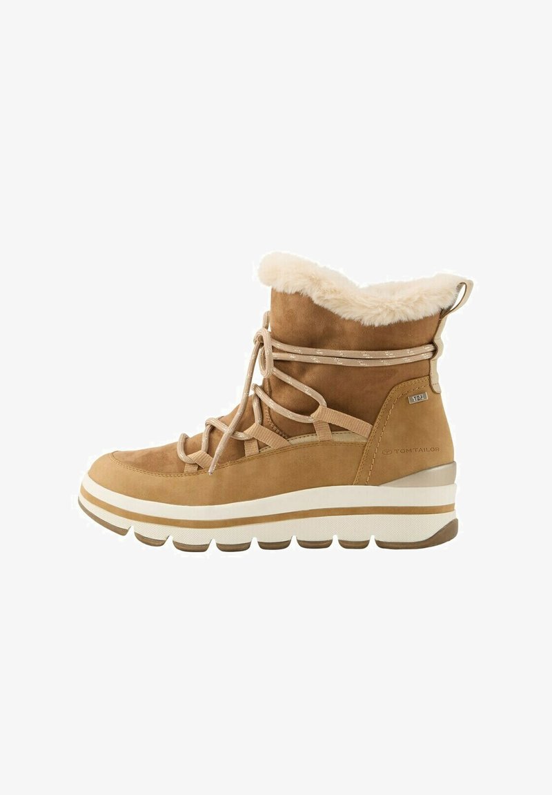 Stivaletto alla caviglia in suede tan con foderatura in pelliccia sintetica, allacciatura frontale e suola intermedia bianca con strisce marroni. Suola chunky per stabilità.