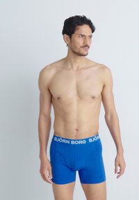 Boxer shorts in cotone blu con una cintura elastica brandizzata che presenta la scritta "BJÖRN BORG" in bianco. Progettati per una vestibilità aderente e una texture liscia.