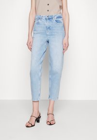 Jeans de mezclilla azul claro con un ajuste relajado, pierna ligeramente entallada, cintura de media altura y diseño de cinco bolsillos. Cuenta con un dobladillo sin rematar en el tobillo.