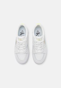 Pair of white Calvin Klein sneakers with mesh panels, laces, and logo on tongue and side, shown from above on a light background.