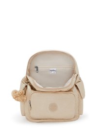 Lo zaino beige Kipling presenta una chiusura con zip, molteplici tasche, una texture liscia e un portachiavi a forma di scimmia. Include una tasca interna con zip.
