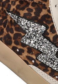 Zapatilla de leopardo con acabado de gamuza texturizada, que presenta un detalle de rayo plateado brillante en el lateral y un ribete de cuero crema.