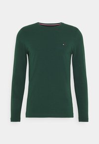 Long-sleeve green t-shirt made of soft cotton, featuring a round neck and a small logo in red, white, and blue on the chest.