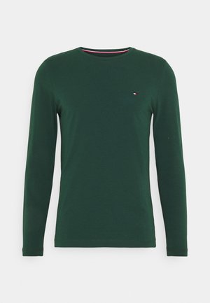 Lange mouw groene t-shirt van zachte katoen, met een ronde hals en een klein logo in rood, wit en blauw op de borst.
