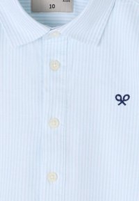 Polo de rayas azul claro para niños, con cuello de punta, tapeta de cuatro botones y un pequeño detalle bordado en marino.