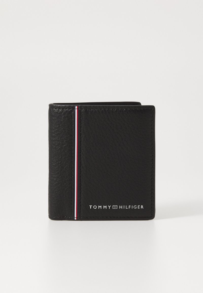 Must mustabehnikk rahakott, millel on tekstureeritud viimistlus, vertikaalne punane, valge ja sinine riba ning reljeefne "TOMMY HILFIGER" logo.