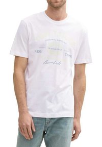 T-shirt en coton blanc avec col rond, manches courtes et texte imprimé avec des accents jaune clair et bleu à l'avant.