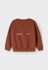 Bruine sweatshirt met een ontspannen pasvorm, geribde manchetten en onderrand, met witte tekst op de achterkant: "ALTIJD AAN HET LOPEN," "DEZE DAG IS DE BESTE DAG," en "WILD EN VRIJ VOOR ALTIJD."
