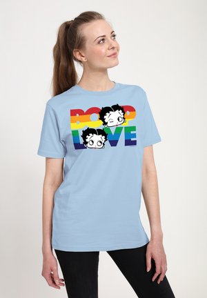 Lyseblå t-shirt med et grafisk print af to udtryksfulde tegneserieansigteter over ordene "BOOP LOVE" i regnbuefarver. Korte ærmer.