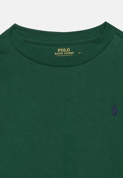 Σκούρο πράσινο μπλουζάκι Polo Ralph Lauren με στρογγυλή λαιμόκοψη, με κίτρινη ετικέτα επωνυμίας στο εσωτερικό του γιακά και μικρό μοβ κεντητό λογότυπο στο στήθος.