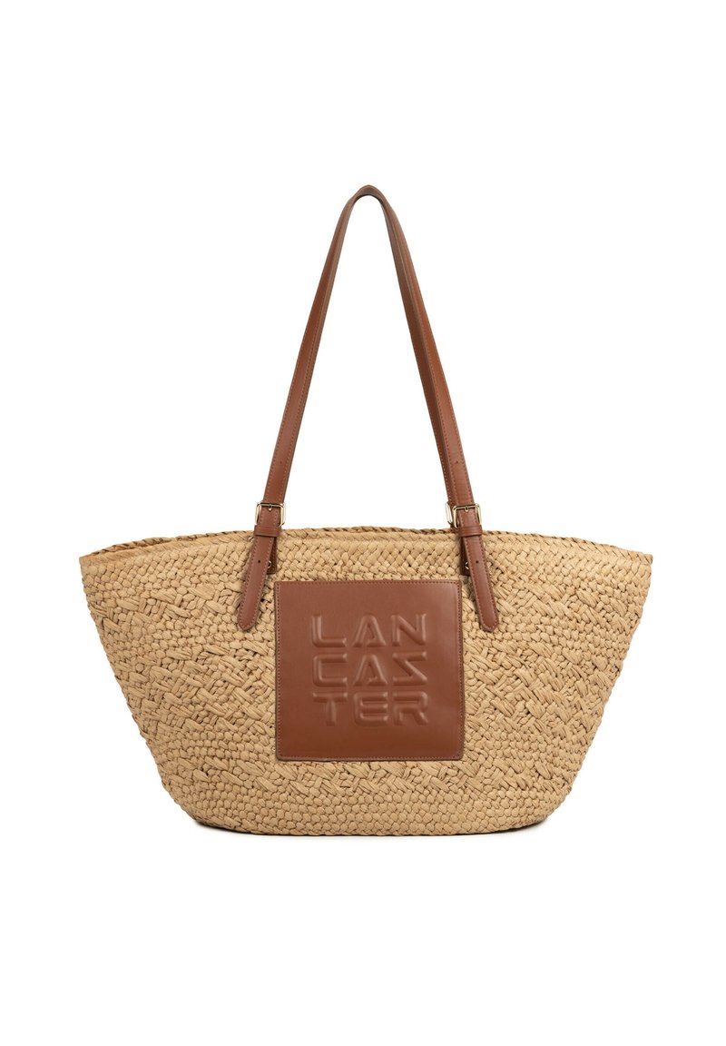 Sac fourre-tout en paille tissée avec poignées en cuir marron et patch en cuir texturé avec le logo "LANCASTER" embossé sur le devant.