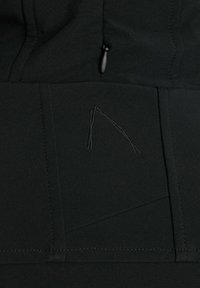Tejido negro de una chaqueta con costuras elegantes, un diseño geométrico sutil y un bolsillo con cremallera con un tirador de color negro.
