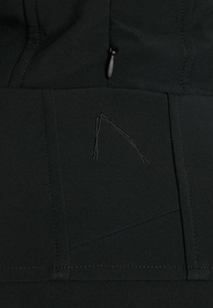 Tessuto nero di una giacca con cuciture eleganti, un sottile design geometrico e una tasca con zip dotata di un tirazip nero.