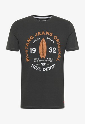 T-shirt en coton gris présentant un motif rond en orange et blanc avec le texte "Mustang Jeans Original", un surf et l'année 1932.