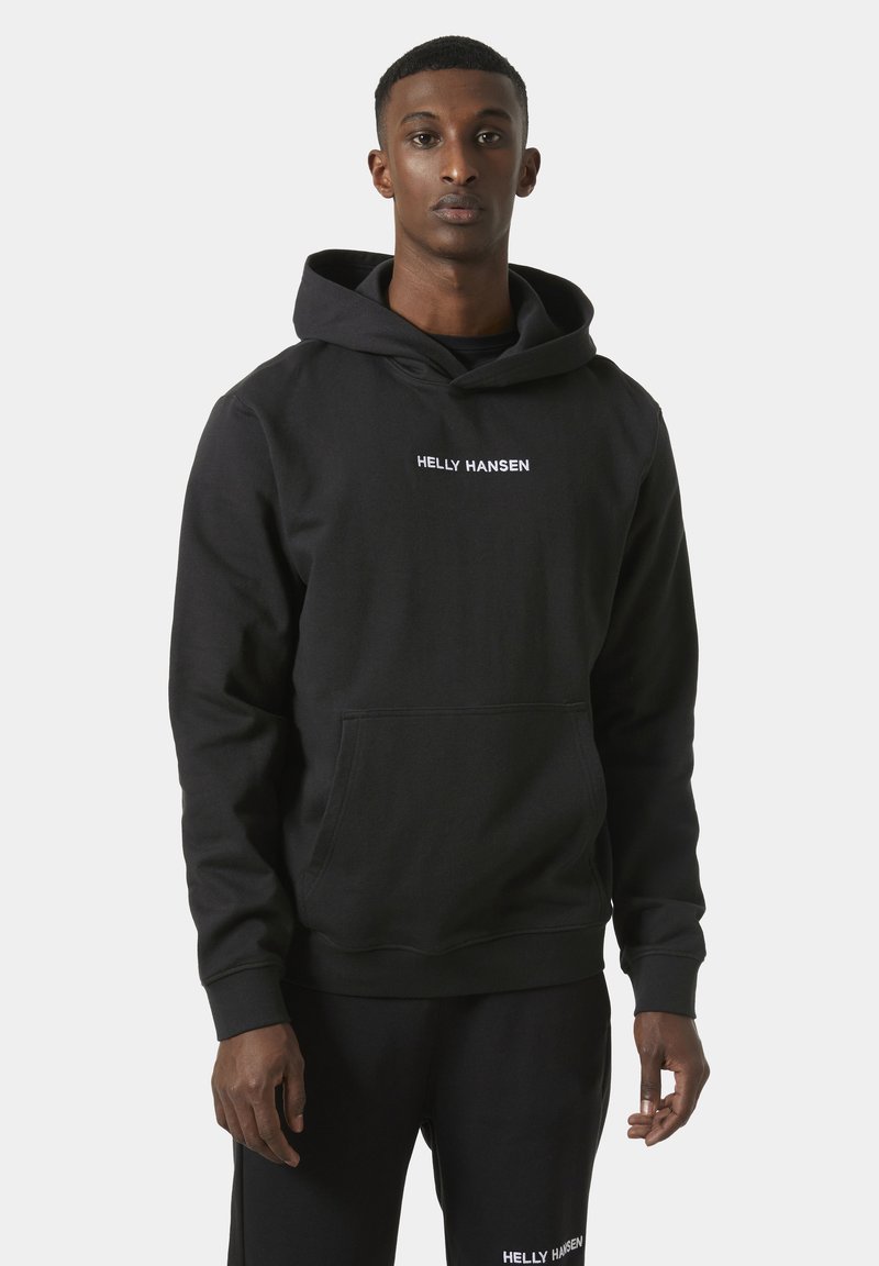 Black hoodie made of cotton blend with a front pocket; features white embroidered logo "HELLY HANSEN" on the chest and a drawstring hood.