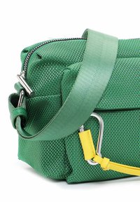 Borsa in tessuto verde con una tracolla verde abbinata e un accento giallo. Presenta hardware in argento e una chiusura a zip prominente.