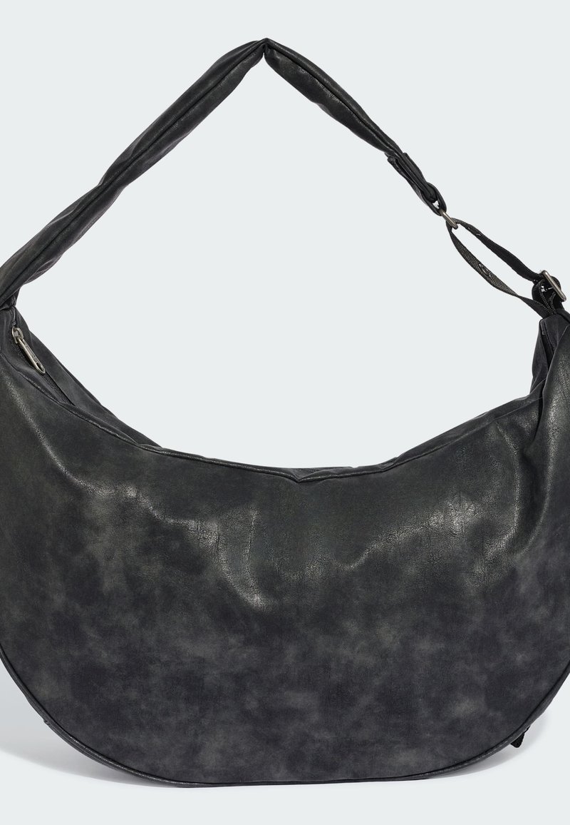 Schwarze, aus Leder gefertigte Schultertasche in Halbmondform mit gepolstertem Träger und einer seitlichen Reißverschlusstasche vor hellem Hintergrund.