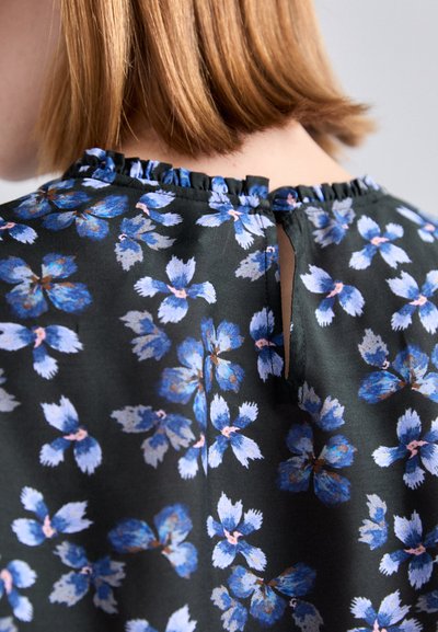 Blumentop aus dunklem Stoff mit blauen und pinken Blumen, einem gerafften Ausschnitt und einer Keyhole-Öffnung auf der Rückseite.