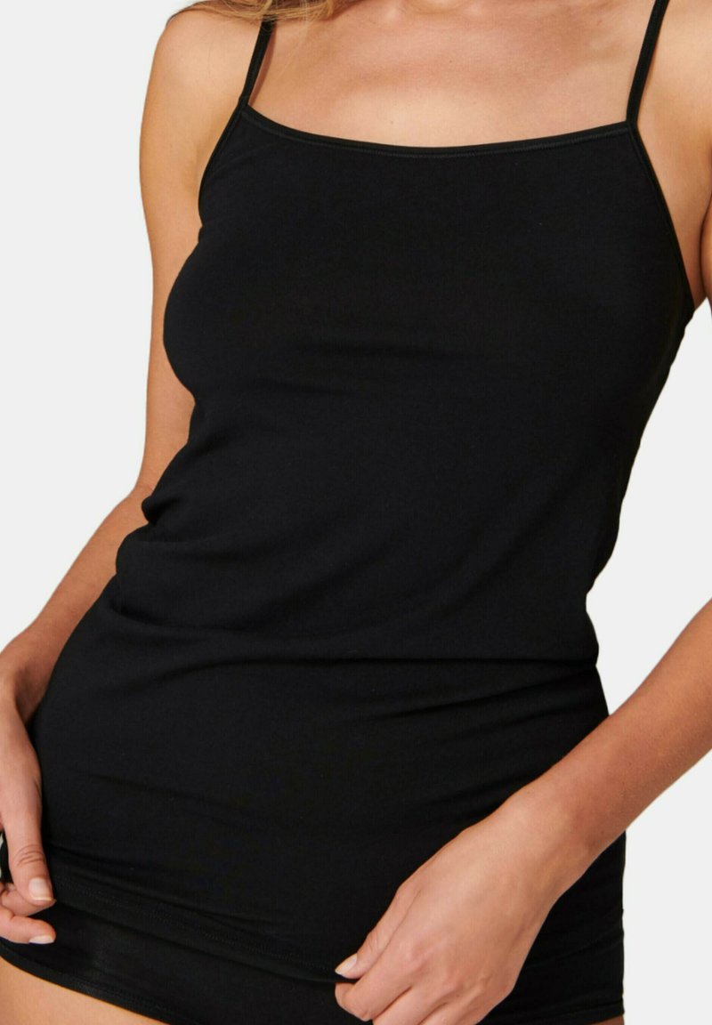 Sort camisole-top med tynde stropper, lavet af blødt, strækbart stof. Har et tætsiddende design og en glat overflade.