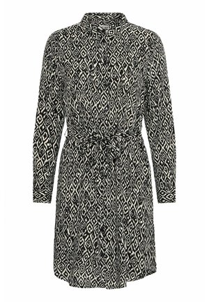 Mustvalge mustriga kleit pikkade varrukatega, krae, nööbiga kinnitamine ja seotud talje detail. Omab rombikujulist geomeetrilist mustrit.