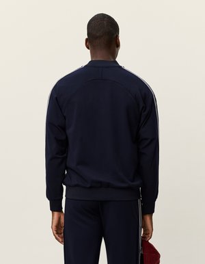 Marineblå träningsjacka med rund hals, ribbade ärmar och sidostrecker. Slät tyg med avslappnad passform och utan synliga logotyper.