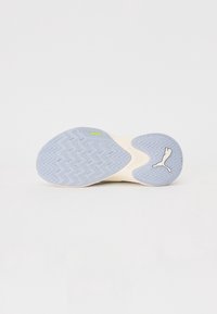 Sole lehce béžové tenisky Puma se světle modrým vzorem, text "PUMAGRIP" a logo Puma na bílém pozadí.