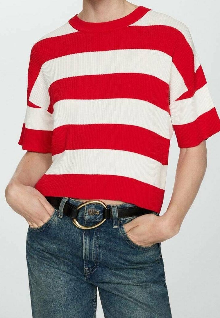 Personne portant un t-shirt à manches courtes à larges rayures horizontales rouges et blanches, rentré dans un jean bleu avec une ceinture noire à boucle ronde dorée.