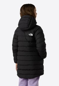 Doudoune noire avec un design matelassé horizontal, dotée d'une capuche et d'un logo sur le haut du dos. Texture lisse et brillante, avec une coupe jusqu'aux genoux.